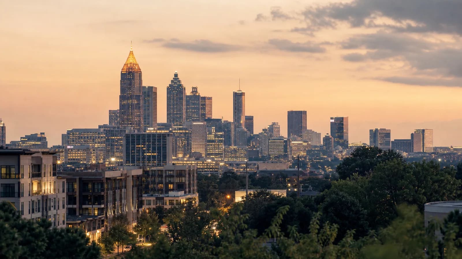 Atlanta skyline from a Midtown or West Midtown vantage at dusk — Buckhead towers in the distance, warm city light, sophisticated.