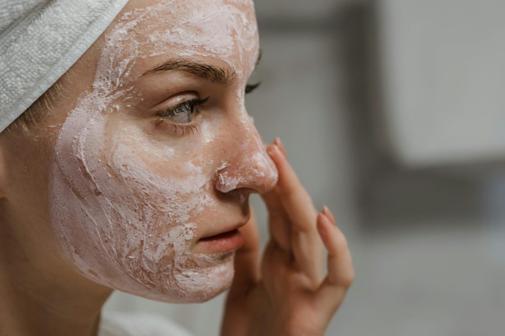 Woman applying Bubolo Medical skincare products to her face to improve the appearance of her skin.